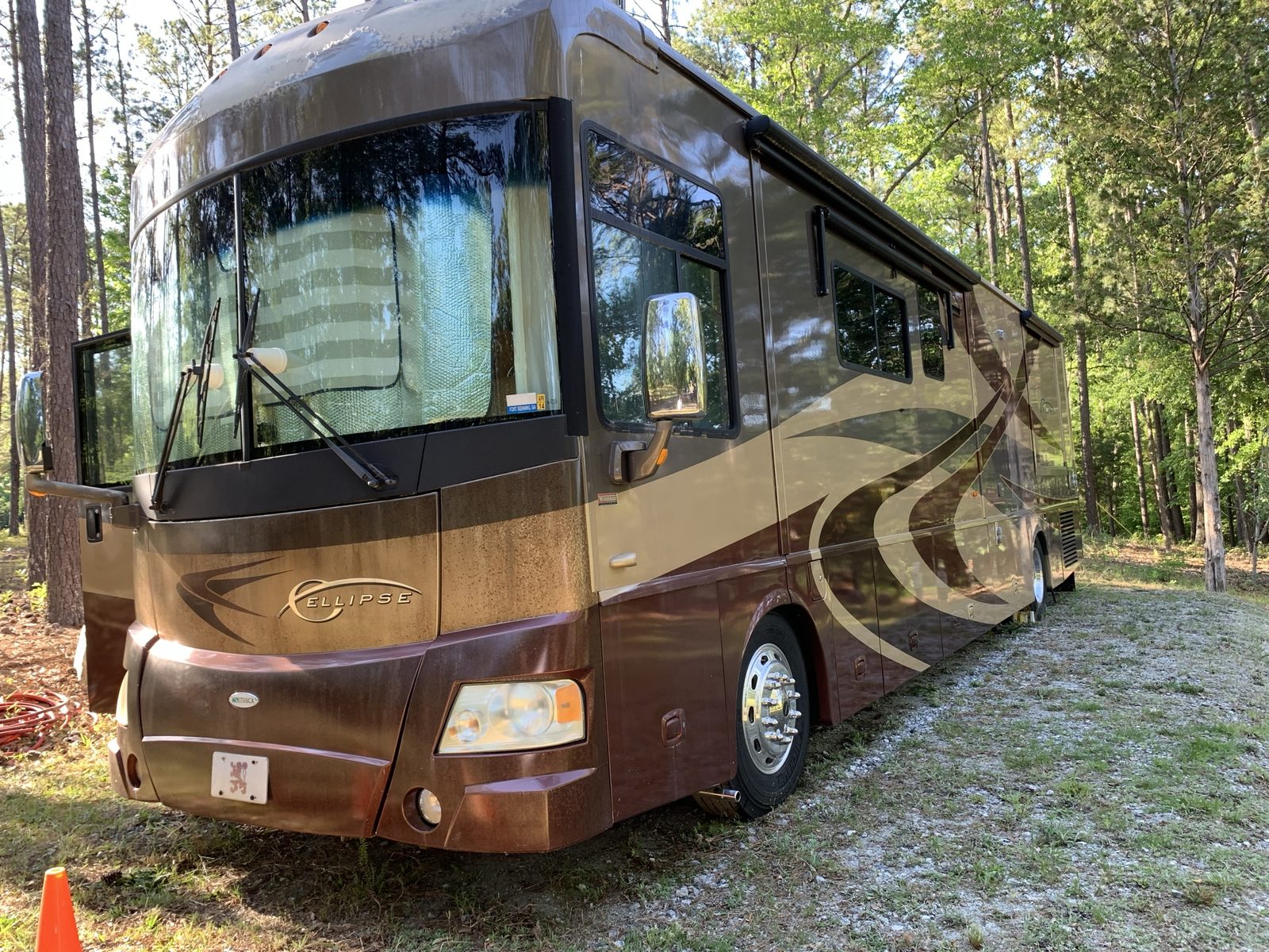 Ellipse Class A diesel motorhome at a wooded campsite