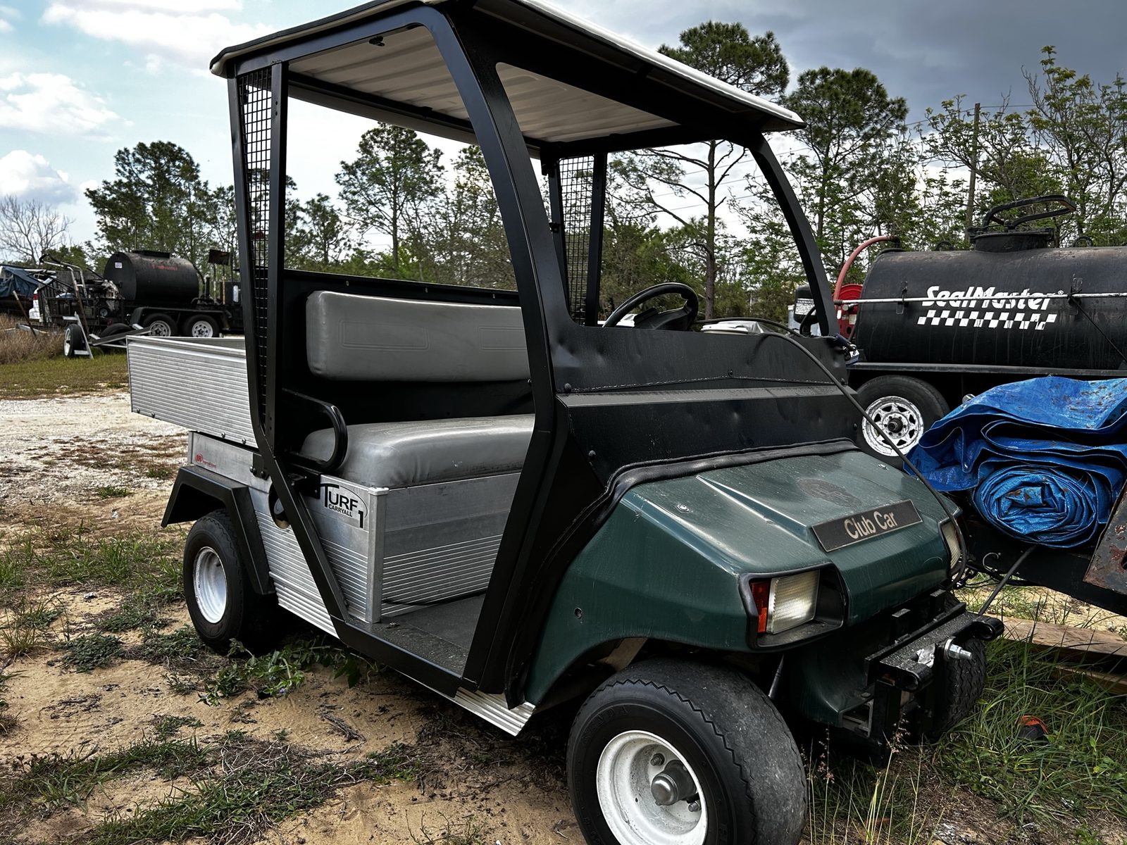 Club Car utility golf cart parked in a gravel yard