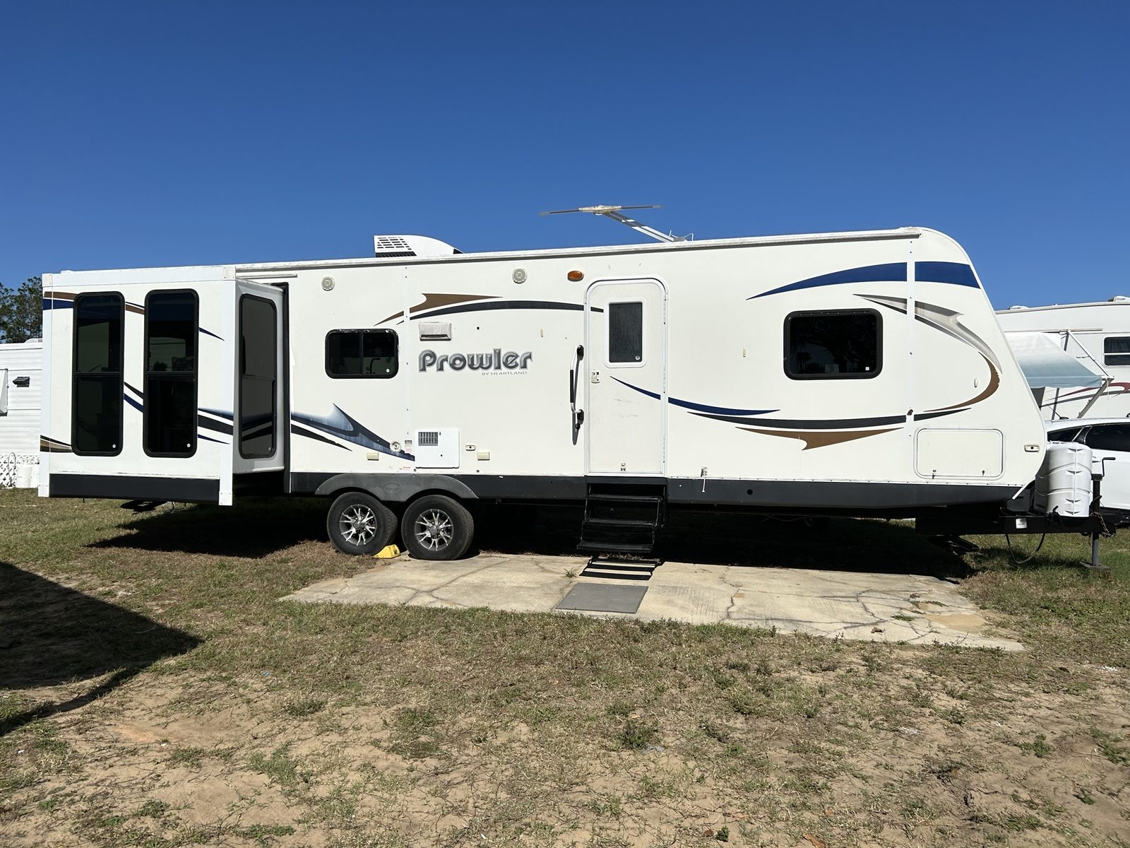 Prowler travel trailer by Heartland in an open grassy lot